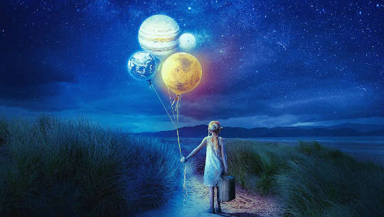 little girl holding a suitcase and balloons that look like the planets