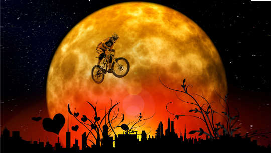 young boy on a bicycle "flying in front of the moon"