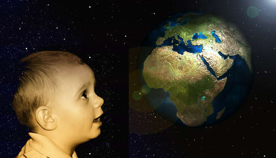 a child looking up at a globe of planet earth