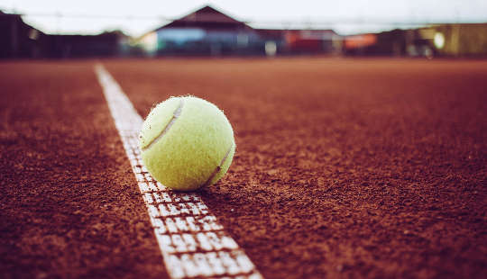tennis ball sitting on the white line