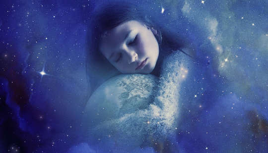 a young girl sleeps curved around planet earth and holding it in her arms