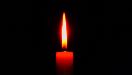 a single red candle with a steady flame